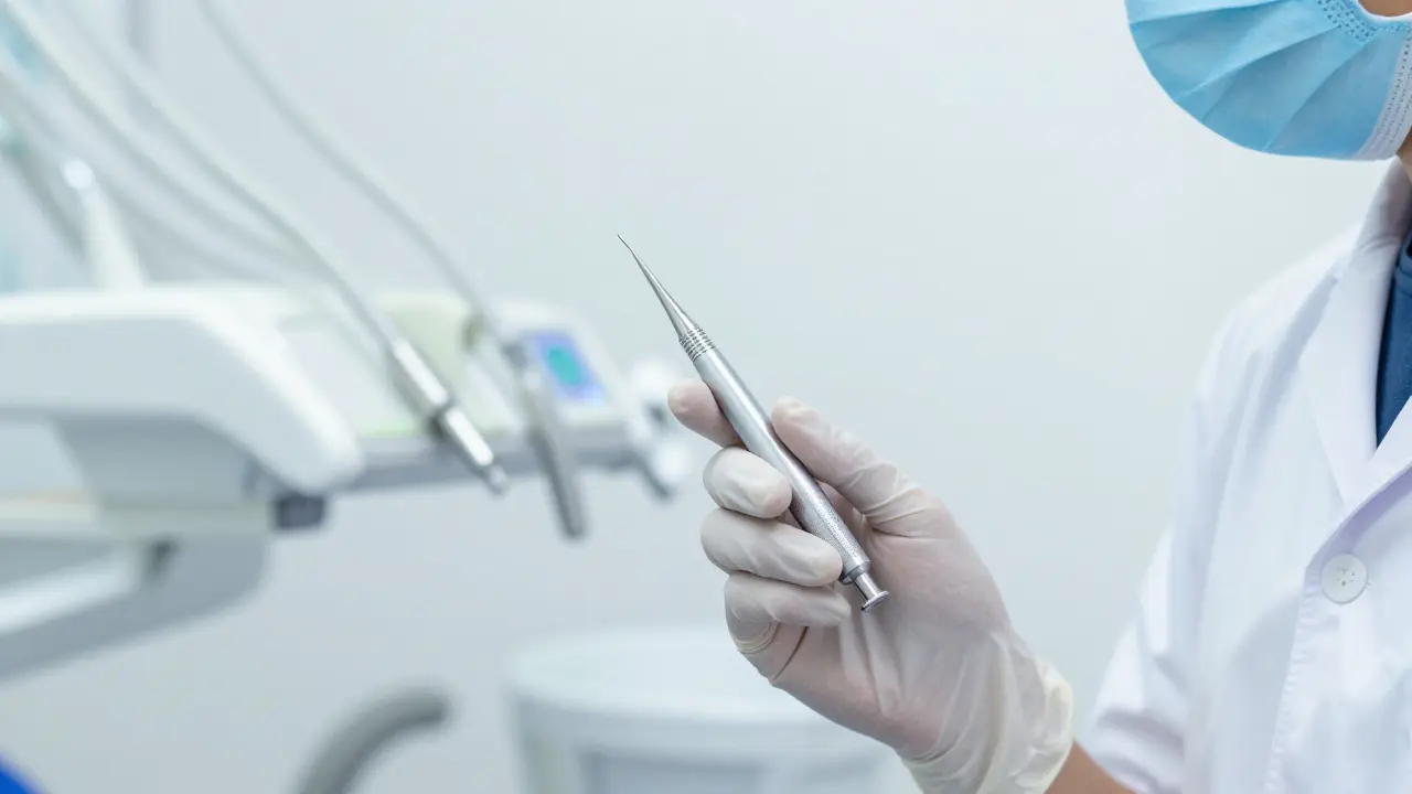 Detail profesionálního nástroje v rukou zubního lékaře v čisté ordinaci.
